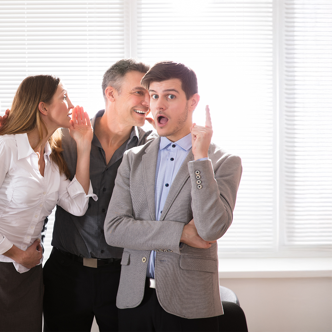 Business Colleague Whispering Secret Gossip To An Amazed Shocked Man With Wide Open Mouth